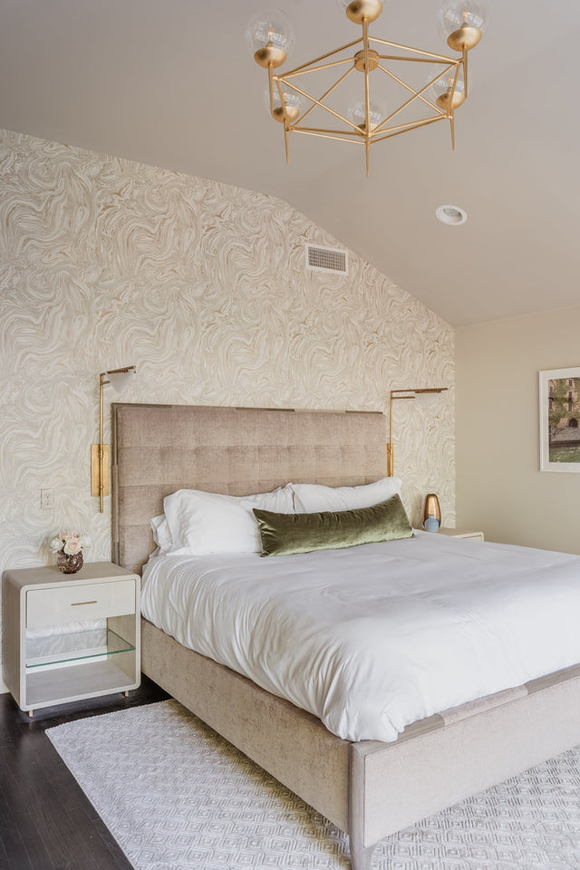 Elegant bedroom with sophisticated wall paneling, textured wallpaper, and warm lighting, creating a refined and inviting atmosphere.